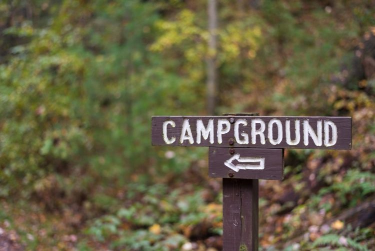 closeup of a wooden campground sign with arrow alo RFTU6YC